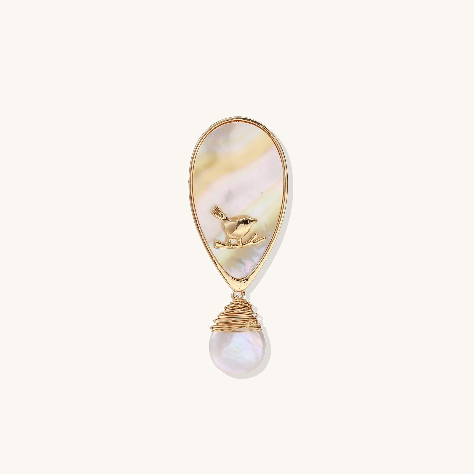 Teardrop-shaped pin with iridescent golden shell, small gold frog figure, and baroque pearl drop on white background.