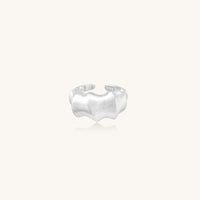 Chunky sterling silver ring with organic flowing design and brushed matte finish on neutral background