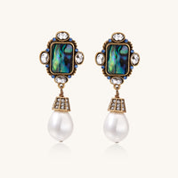 Gold-plated brass drop earrings featuring iridescent abalone shell centers, crystal accents, and white pearl drops.