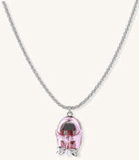 Delicate gold-plated chain necklace with transparent pink-tinted capsule pendant containing decorative bow element