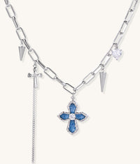 18K gold plated brass chain necklace featuring blue cross pendant with zirconia center stone and spike charms on white background.