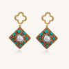 Gold quatrefoil stud earrings with ornate square pendants featuring turquoise stones and freshwater pearls