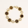 Ornate gold-plated bracelet with alternating brown tiger's eye stones and white freshwater pearls in crystal-accented settings