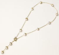 Long gold-plated lariat necklace featuring baroque pearls with metal caps arranged in elegant Y-shape design