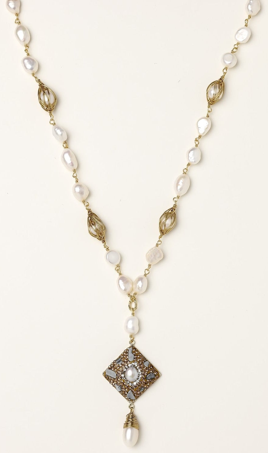 Elegant 14K gold plated necklace with freshwater pearls and ornate crystal diamond pendant on cream background.