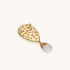 Teardrop-shaped pin with iridescent golden shell, small gold frog figure, and baroque pearl drop on white background.