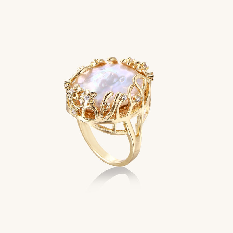 Ornate gold-plated ring with large baroque pearl in decorative vine-like setting with small crystal accents