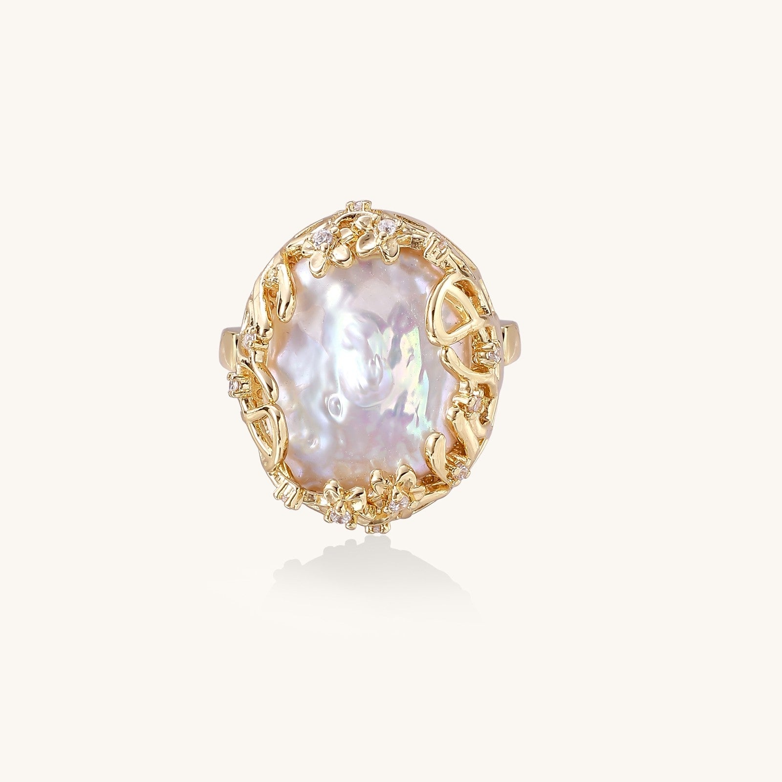Ornate gold-plated ring with large baroque pearl in decorative vine-like setting with small crystal accents
