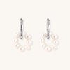 Sterling silver huggie hoop earrings with clustered white freshwater pearls and crystal accents on white background.