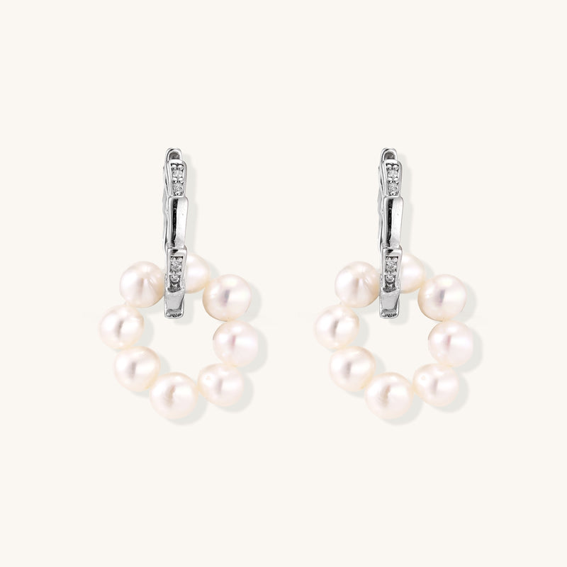 Sterling silver huggie hoop earrings with clustered white freshwater pearls and crystal accents on white background.