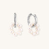 Sterling silver huggie hoop earrings with clustered white freshwater pearls and crystal accents on white background.