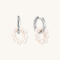Sterling silver huggie hoop earrings with clustered white freshwater pearls and crystal accents on white background.