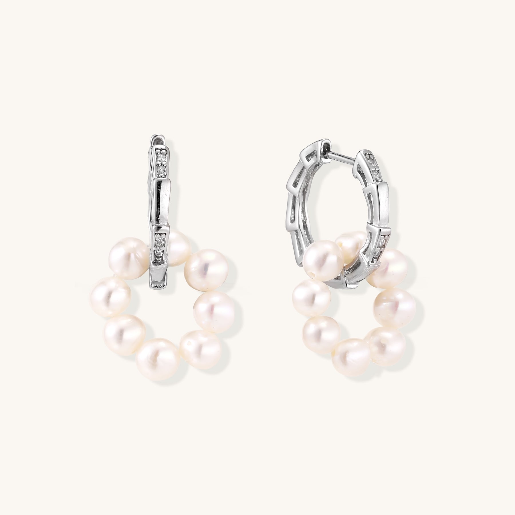 Sterling silver huggie hoop earrings with clustered white freshwater pearls and crystal accents on white background.