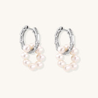 Sterling silver huggie hoop earrings with clustered white freshwater pearls and crystal accents on white background.