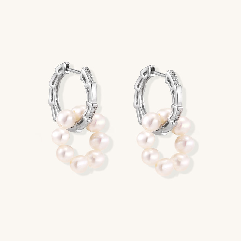 Sterling silver huggie hoop earrings with clustered white freshwater pearls and crystal accents on white background.
