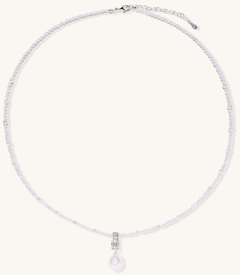 Delicate beaded necklace with lavender crystals, white pearls, and crystal pendant with pearl drop on white background.