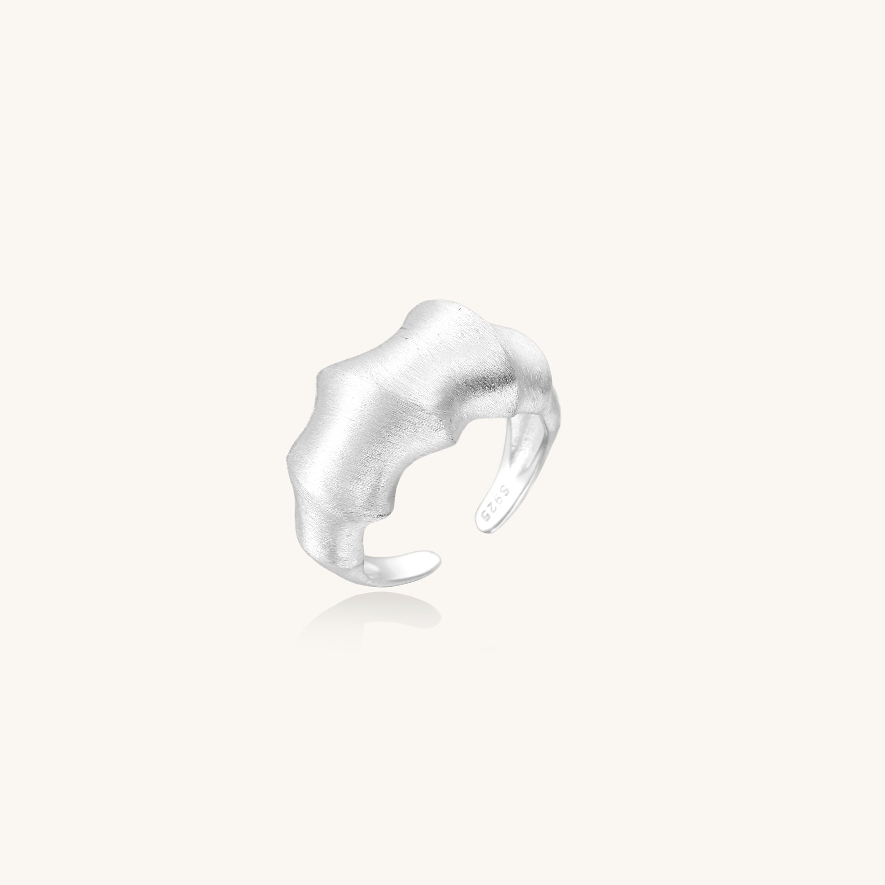 Chunky sterling silver ring with organic flowing design and brushed matte finish on neutral background