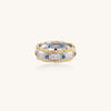 Sterling silver ring with brushed center band, blue zirconia stones, and 24k gold-plated decorative borders.
