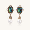 Gold-plated brass drop earrings featuring iridescent abalone shell centers, crystal accents, and white pearl drops.