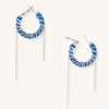 Blue and white checkered denim-wrapped hoop earrings with delicate silver chain dangles on neutral background