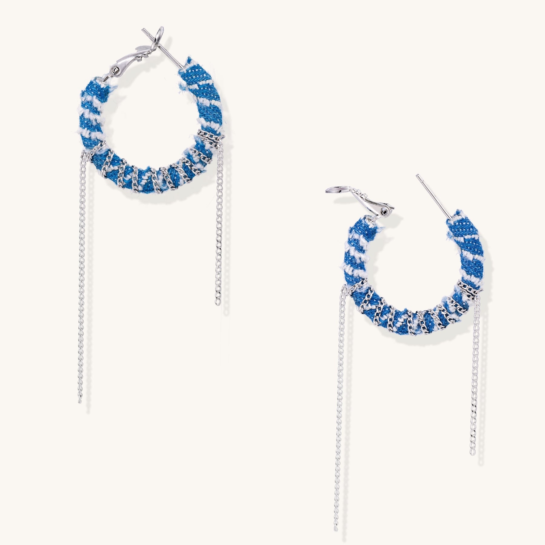 Blue and white checkered denim-wrapped hoop earrings with delicate silver chain dangles on neutral background
