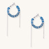 Blue and white checkered denim-wrapped hoop earrings with delicate silver chain dangles on neutral background