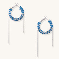 Blue and white checkered denim-wrapped hoop earrings with delicate silver chain dangles on neutral background