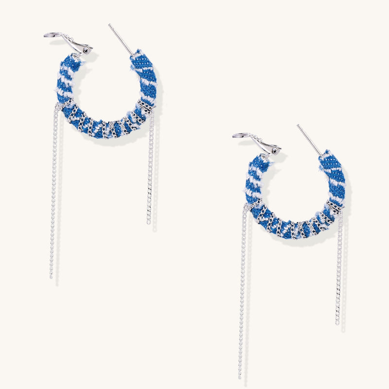 Blue and white checkered denim-wrapped hoop earrings with delicate silver chain dangles on neutral background