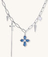 18K gold plated brass chain necklace featuring blue cross pendant with zirconia center stone and spike charms on white background.
