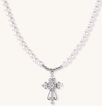 Elegant pearl necklace with ornate 18K gold plated cross pendant featuring zirconia stones on neutral background.