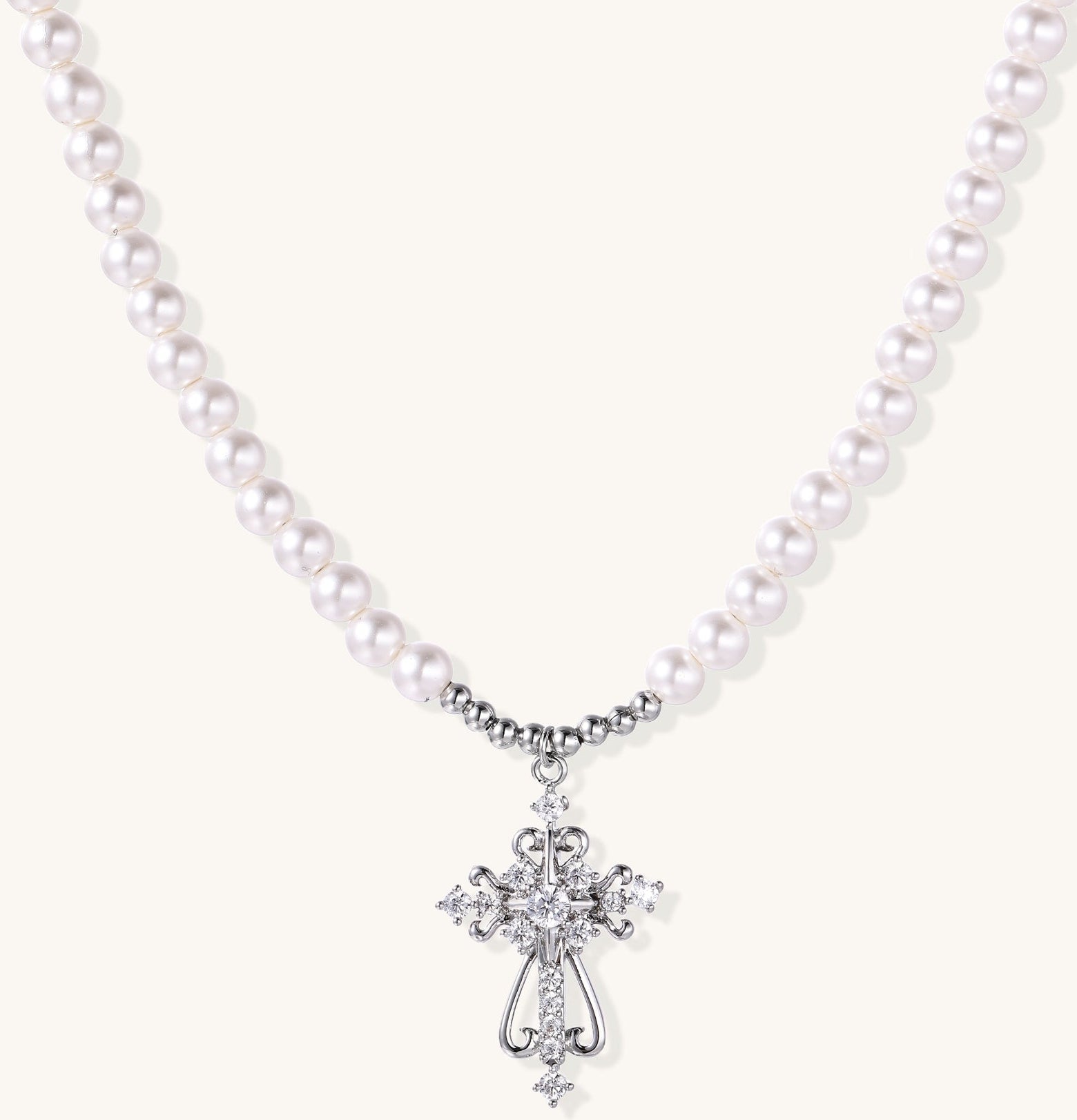 Elegant pearl necklace with ornate 18K gold plated cross pendant featuring zirconia stones on neutral background.