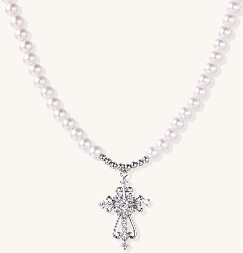 Elegant pearl necklace with ornate 18K gold plated cross pendant featuring zirconia stones on neutral background.