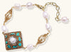 Ornate gold-plated bracelet with square turquoise and crystal centerpiece, freshwater pearls, and decorative chain links