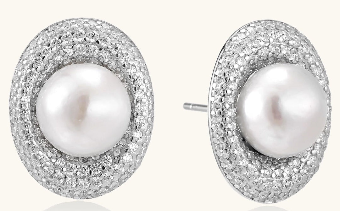 Sterling silver stud earrings with freshwater pearls surrounded by sparkling pavé crystals on white background.