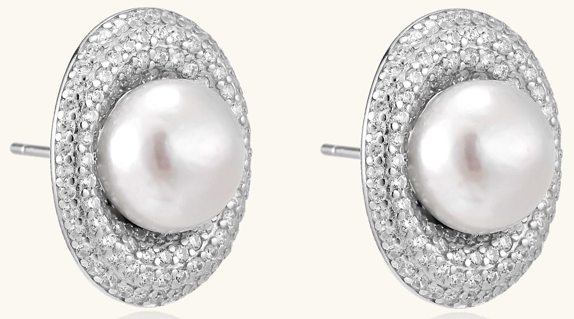 Sterling silver stud earrings with freshwater pearls surrounded by sparkling pavé crystals on white background.