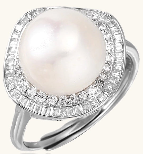 Sterling silver ring with 11mm freshwater pearl surrounded by double diamond halo on white background.
