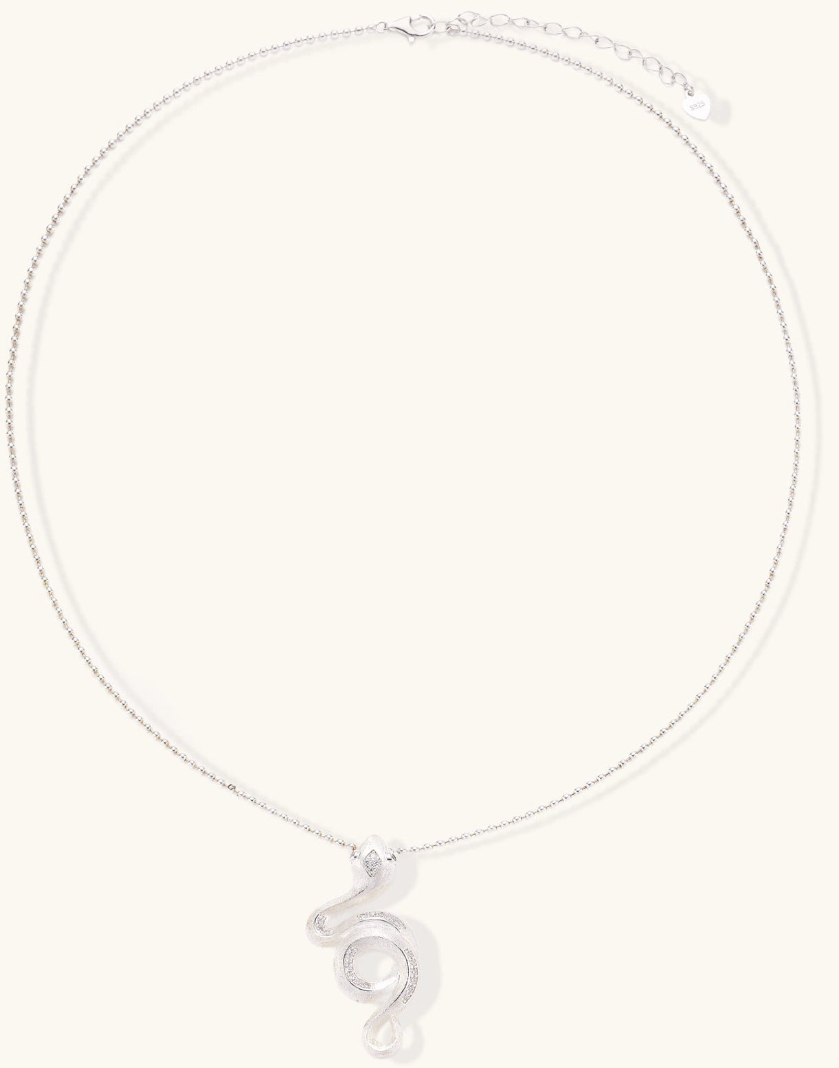 Sterling silver snake pendant necklace with zirconia crystals on adjustable chain against cream background