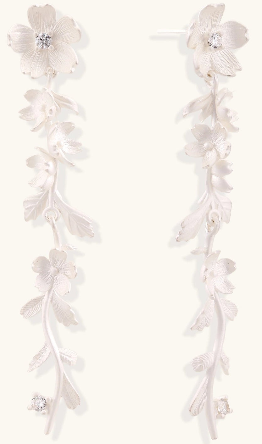 Pair of sterling silver dangle earrings with intricate leaf vine patterns and crystal accents on white background.