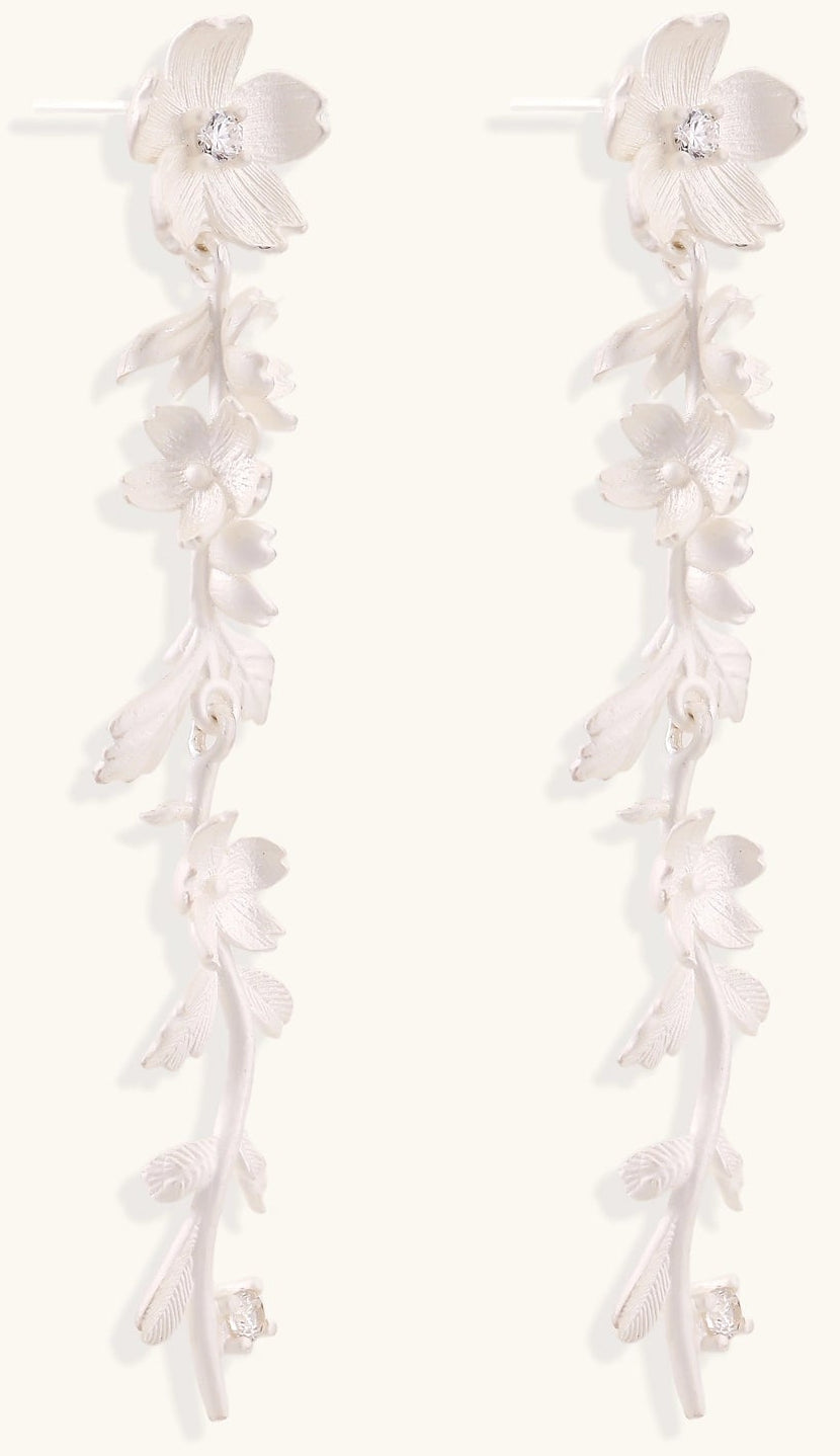 Pair of sterling silver dangle earrings with intricate leaf vine patterns and crystal accents on white background.