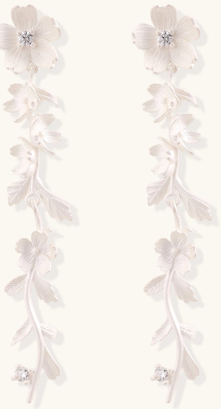 Pair of sterling silver dangle earrings with intricate leaf vine patterns and crystal accents on white background.