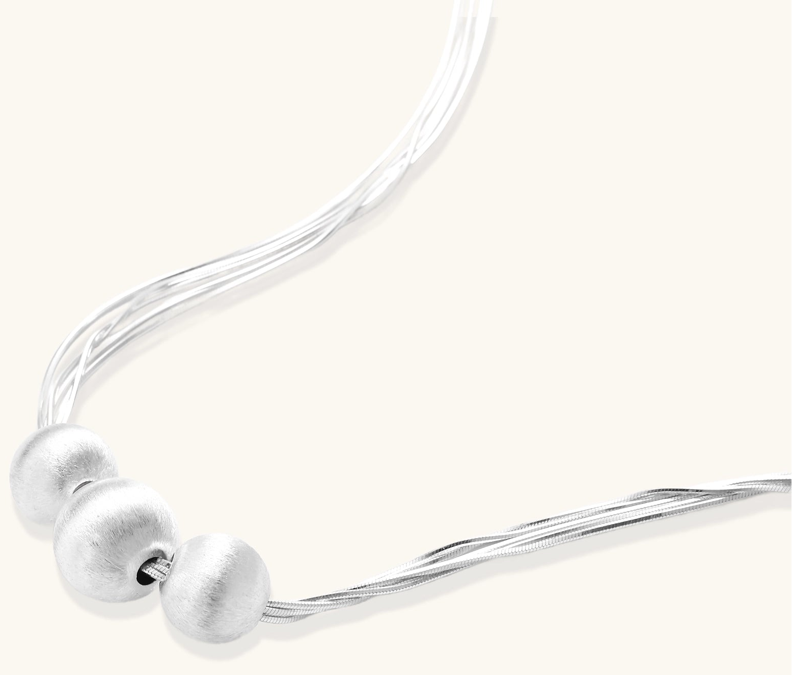 Multi-strand sterling silver necklace with three polished round beads clustered at center on white background.