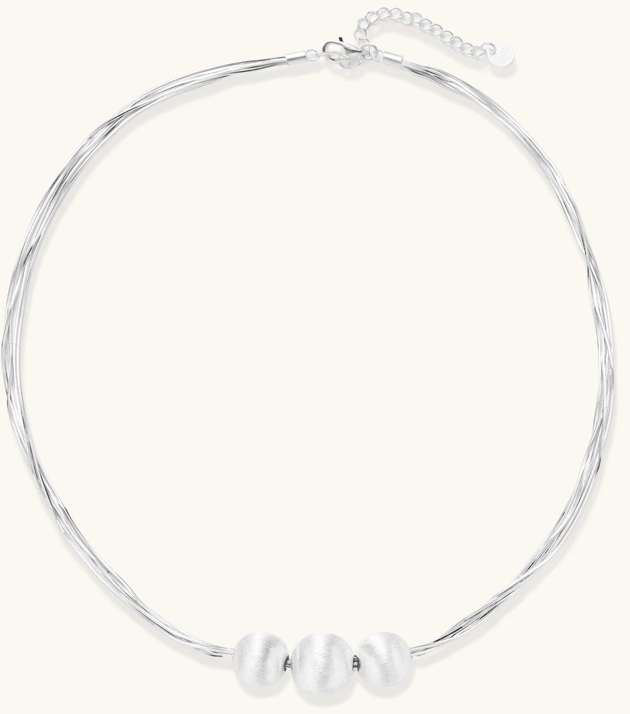 Multi-strand sterling silver necklace with three polished round beads clustered at center on white background.