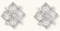 Detailed view of sterling silver stud earrings with geometric filigree design and small freshwater pearls on white background.