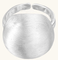 Minimalist sterling silver ring with large brushed disc top and adjustable band on white background.