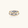 Sterling silver ring with brushed center band, blue zirconia stones, and 24k gold-plated decorative borders.