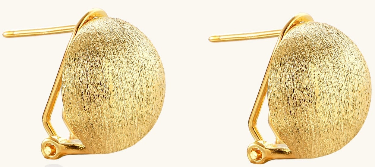 Close-up of textured gold-plated sterling silver dome clip-on earrings with brushed finish on white background.