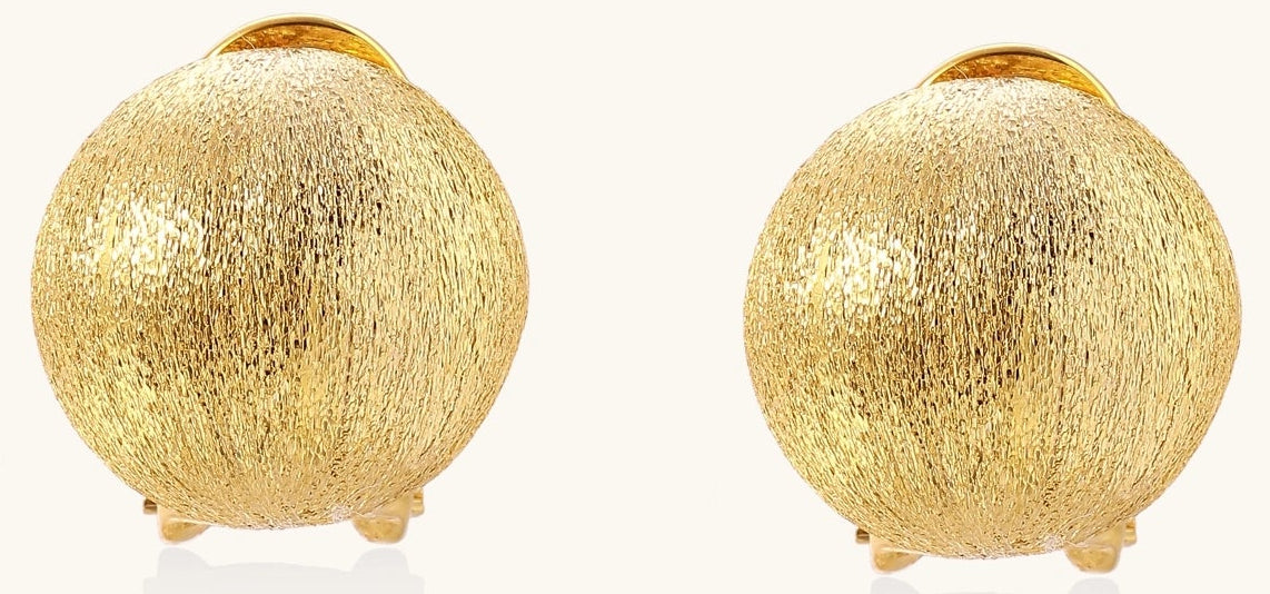 Close-up of textured gold-plated sterling silver dome clip-on earrings with brushed finish on white background.