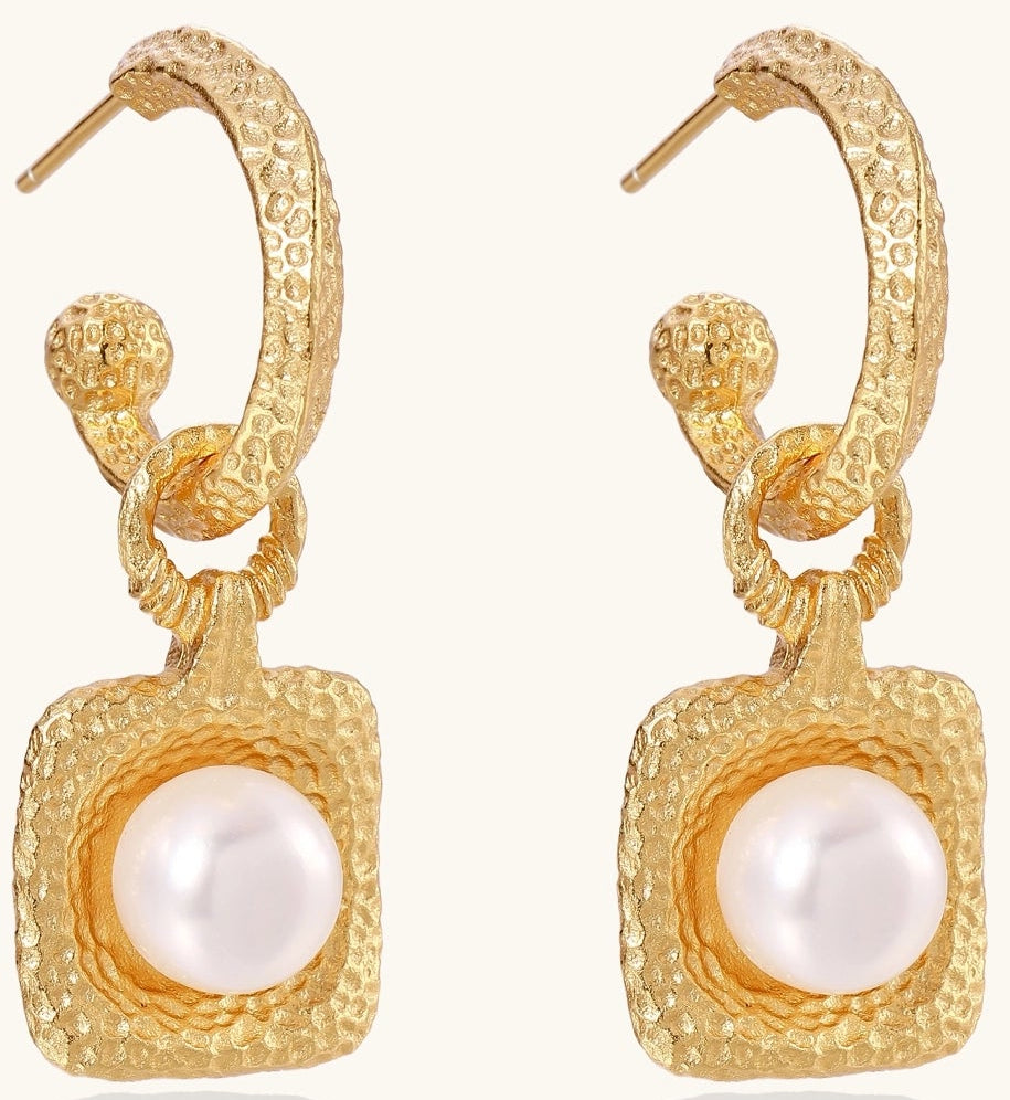 Gold-plated textured hoop earrings with square pendants containing freshwater pearls on white background
