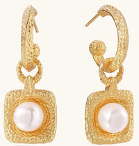 Gold-plated textured hoop earrings with square pendants containing freshwater pearls on white background