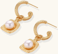 Gold-plated textured hoop earrings with square pendants containing freshwater pearls on white background